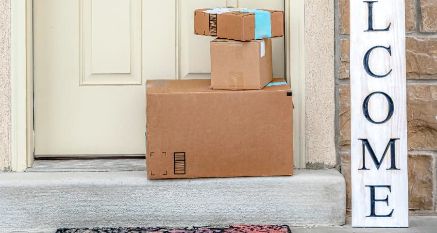 Packages on the doorstep of a home with a welcome sign in Colorado Springs